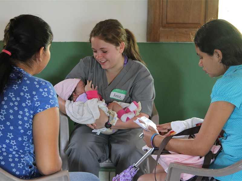 Team member holding infant in Evangelism area