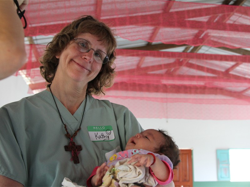 Kathy Holding baby while mother is examined